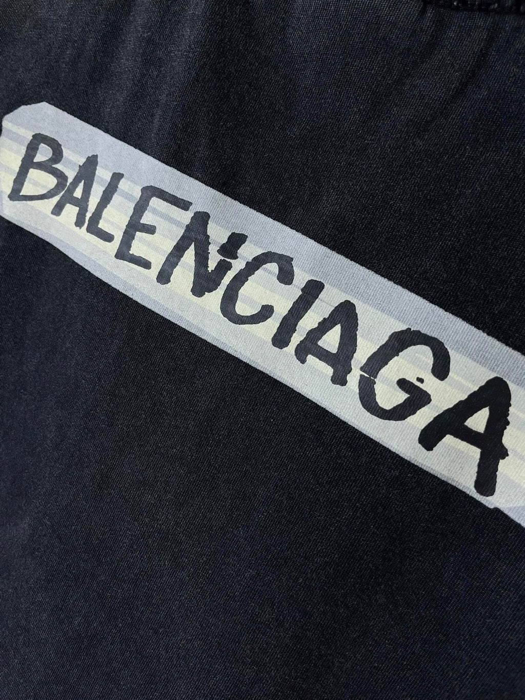 Close-up of BALENCIAGA logo print on dark navy T-shirt fabric