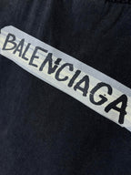 Close-up of BALENCIAGA logo print on dark navy T-shirt fabric