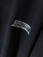 Close-up of dark navy T-shirt with BALENCIAGA logo patch graphic