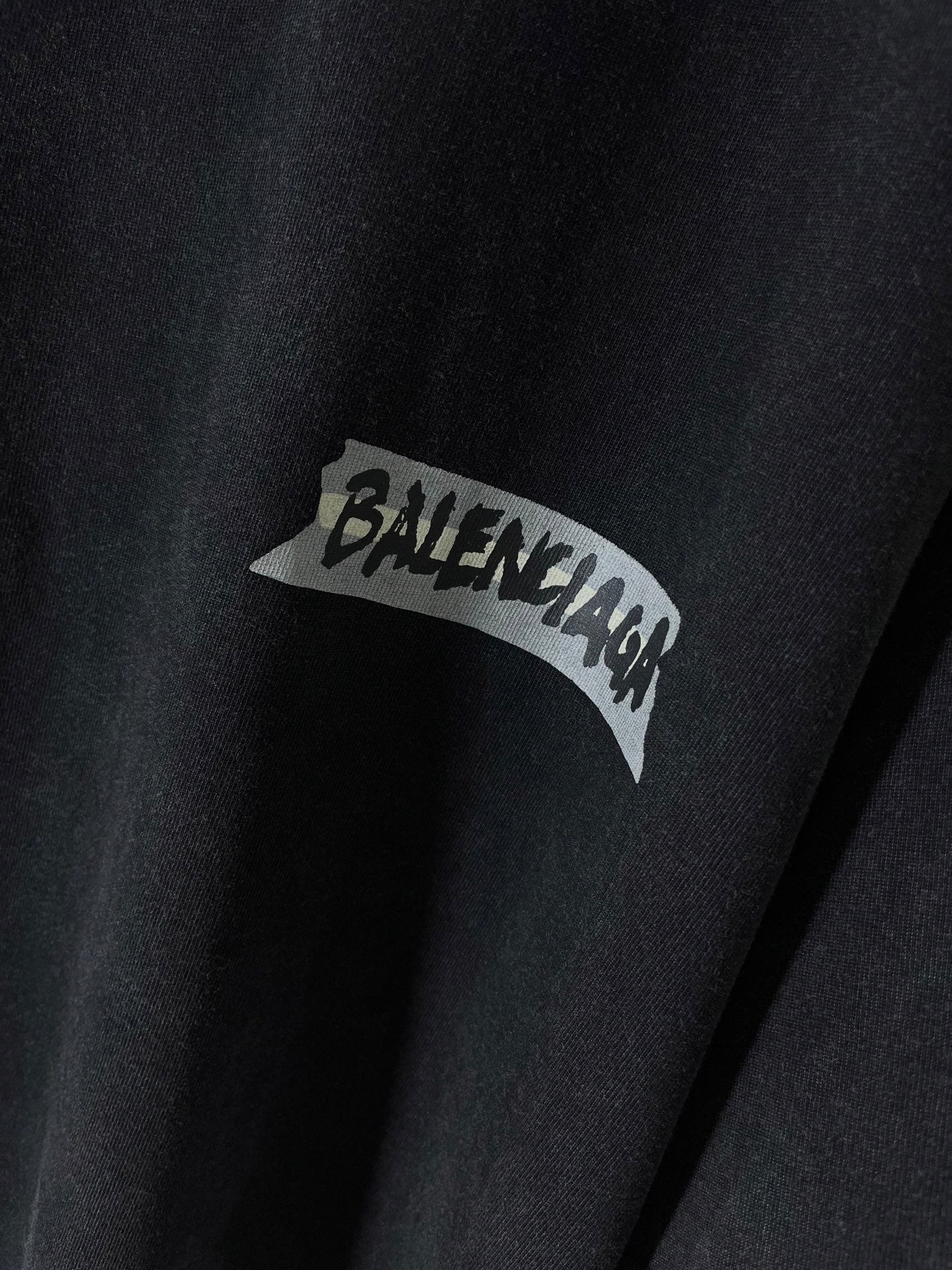 Close-up of dark navy T-shirt with BALENCIAGA logo patch graphic