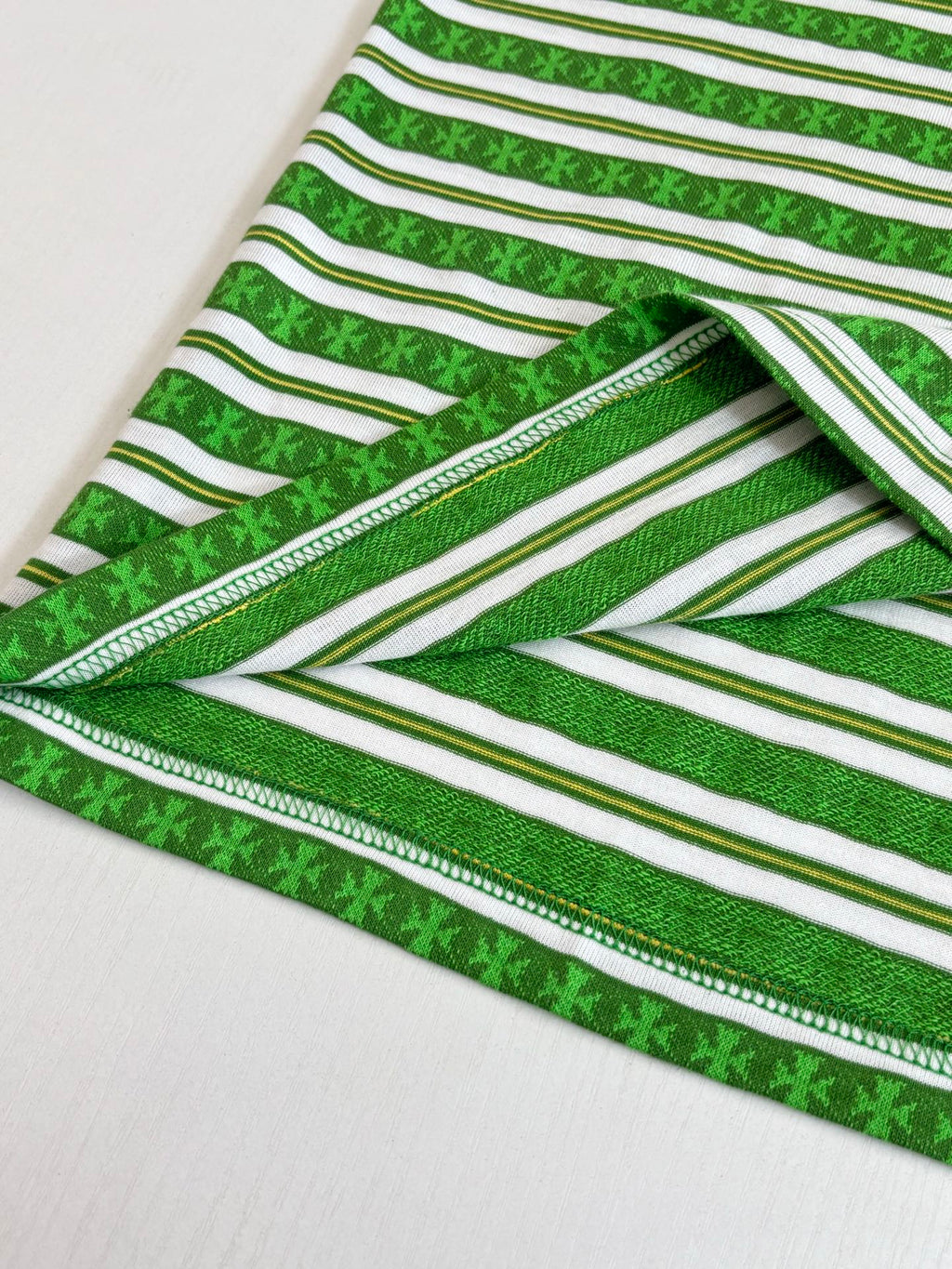 Close-up of green striped T-shirt hem with double-stitched edge