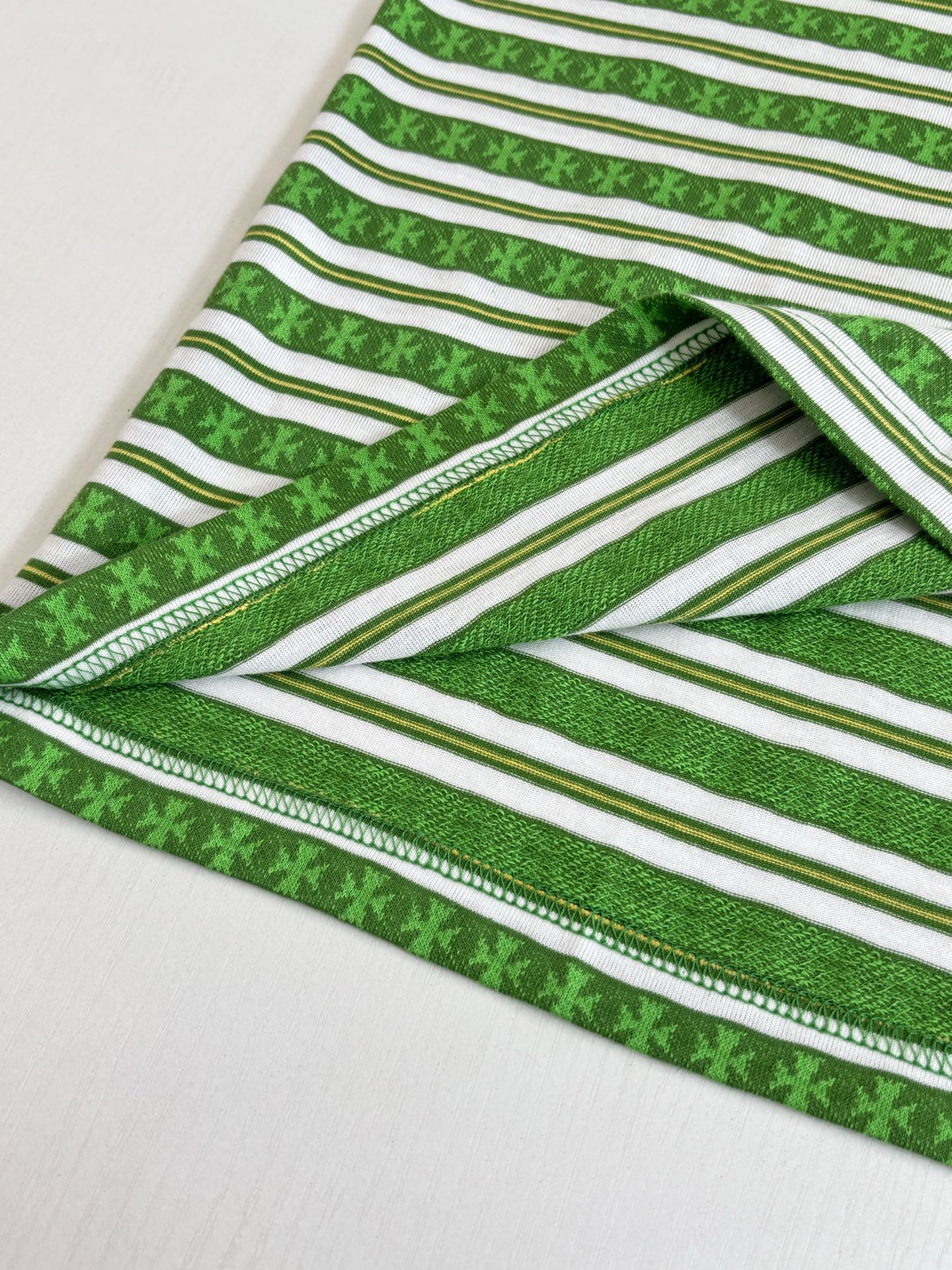 Close-up of green striped T-shirt hem with double-stitched edge