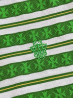 Close-up of green striped knit T-shirt with embroidered crest logo