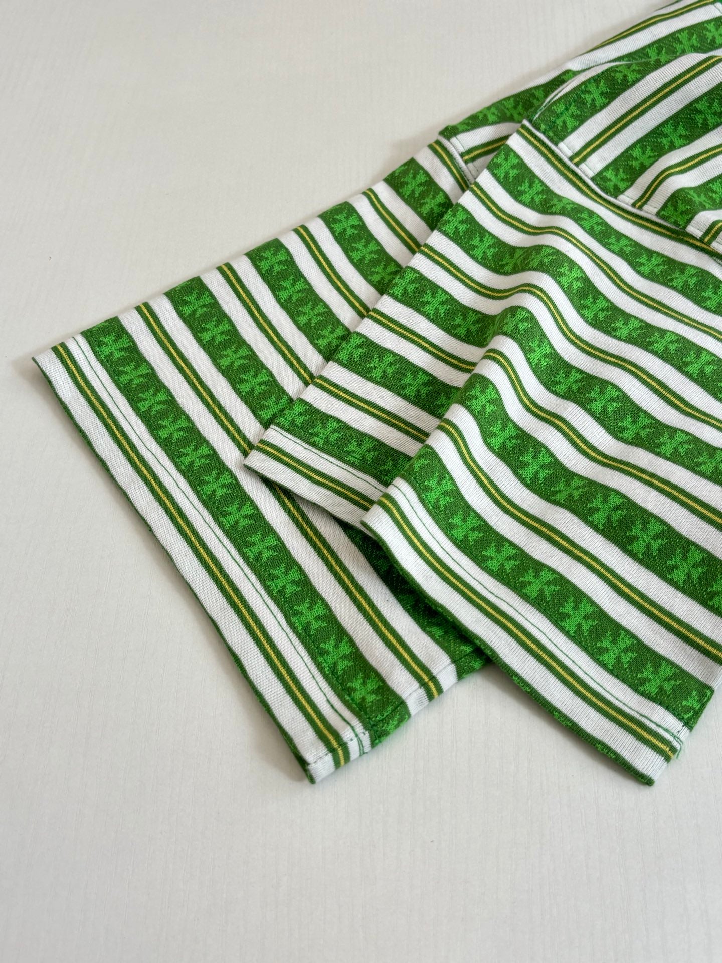 Green striped short-sleeve T-shirt laid flat, crew neck and sleeve visible