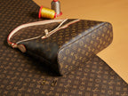 Louis Vuitton monogram bag with red trim, top handles and structured rectangular silhouette
