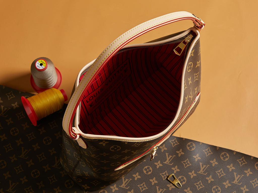 Louis Vuitton monogram bag open view showing red striped lining and top zipper closure