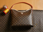Louis Vuitton monogram bag with top handle, front clasp and red-lined interior panel