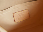 Beige-lined handbag interior with Louis Vuitton logo patch on inner wall