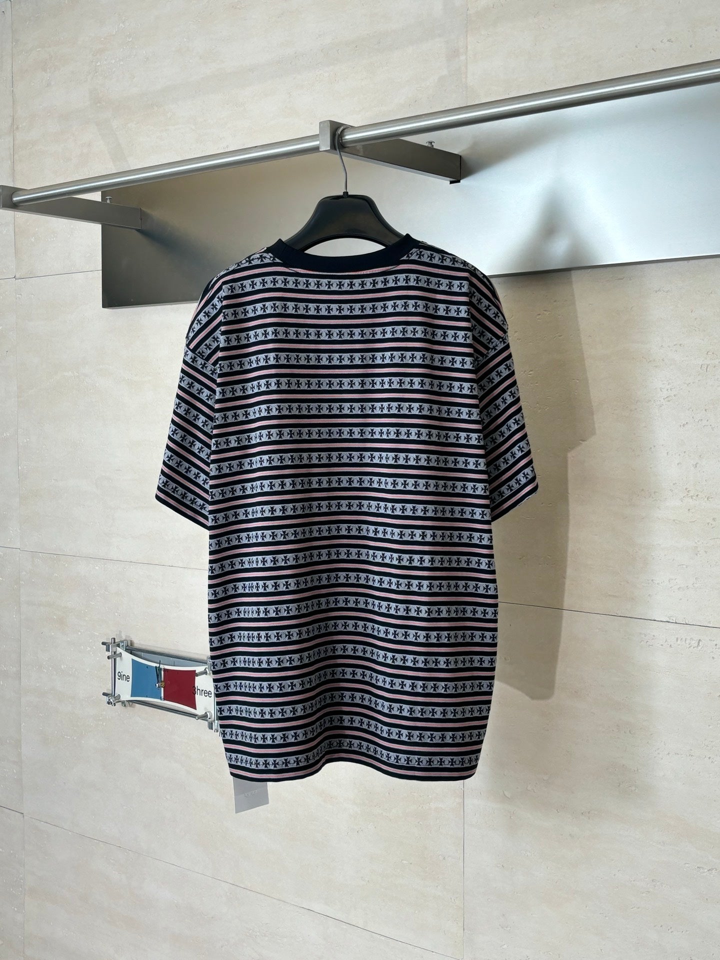Patterned short-sleeve T-shirt with dark stripes, small motifs, and red edging