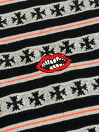 Close-up of striped knit T-shirt with red lip graphic and small dark motifs