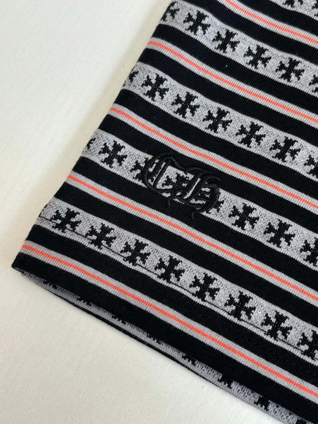 Close-up of striped T-shirt knit with small motif icons and red accent lines