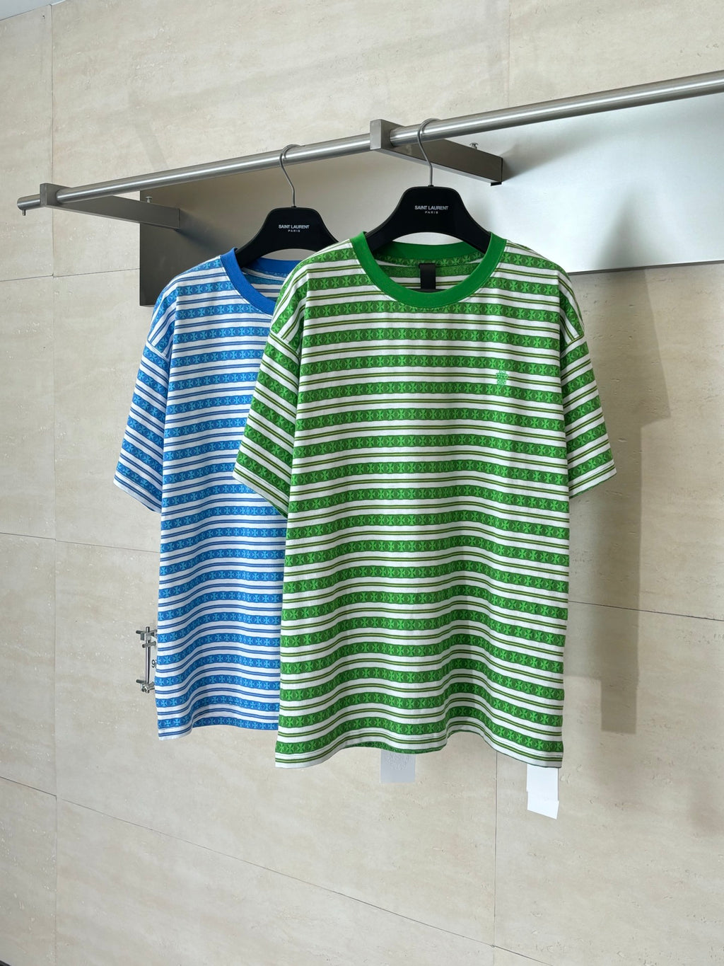 Green striped short-sleeve T-shirt on hanger, visible crew neck and front logo