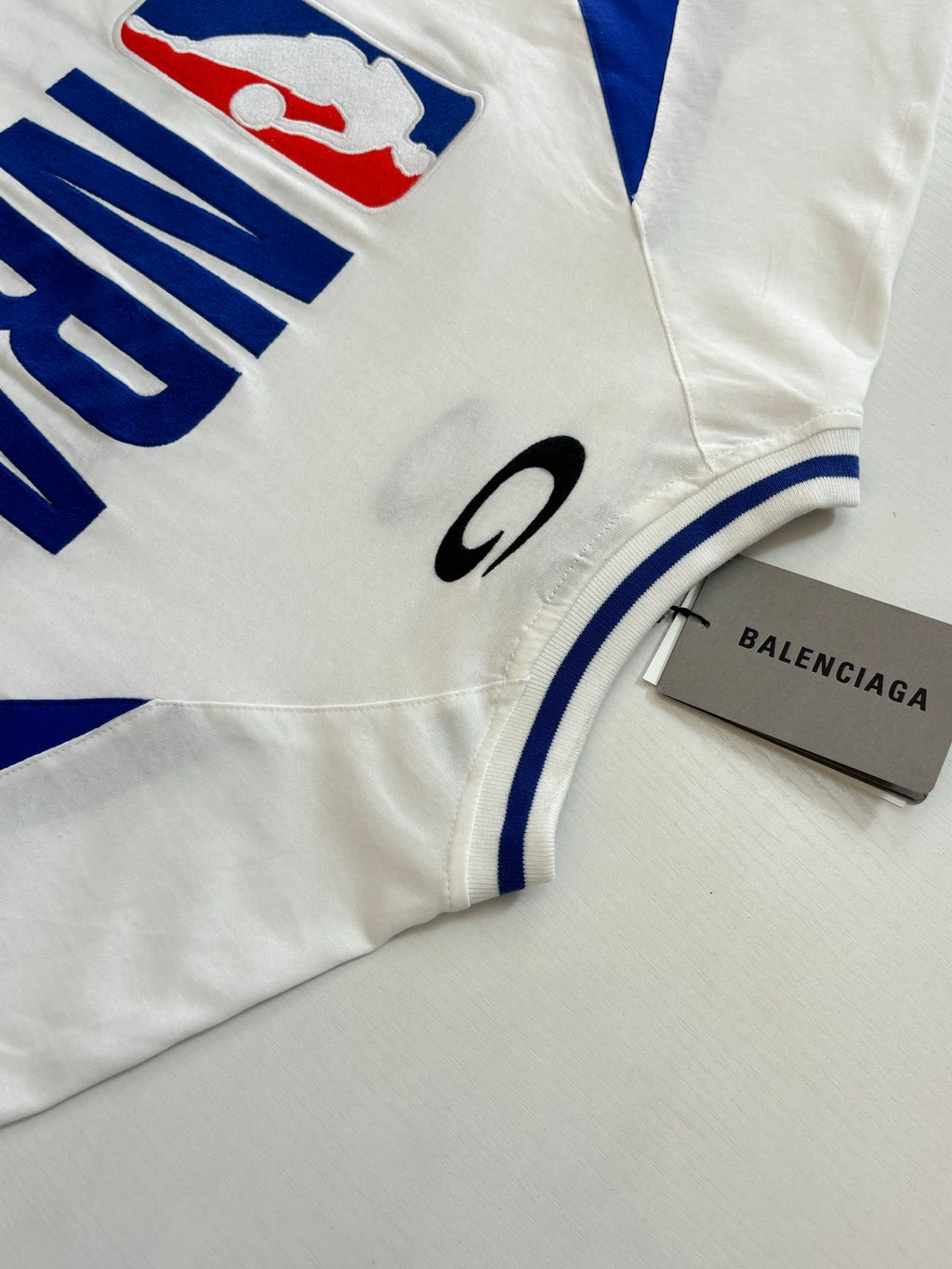 Balenciaga short-sleeve jersey sleeve and chest details with blue stripe and small logo patch
