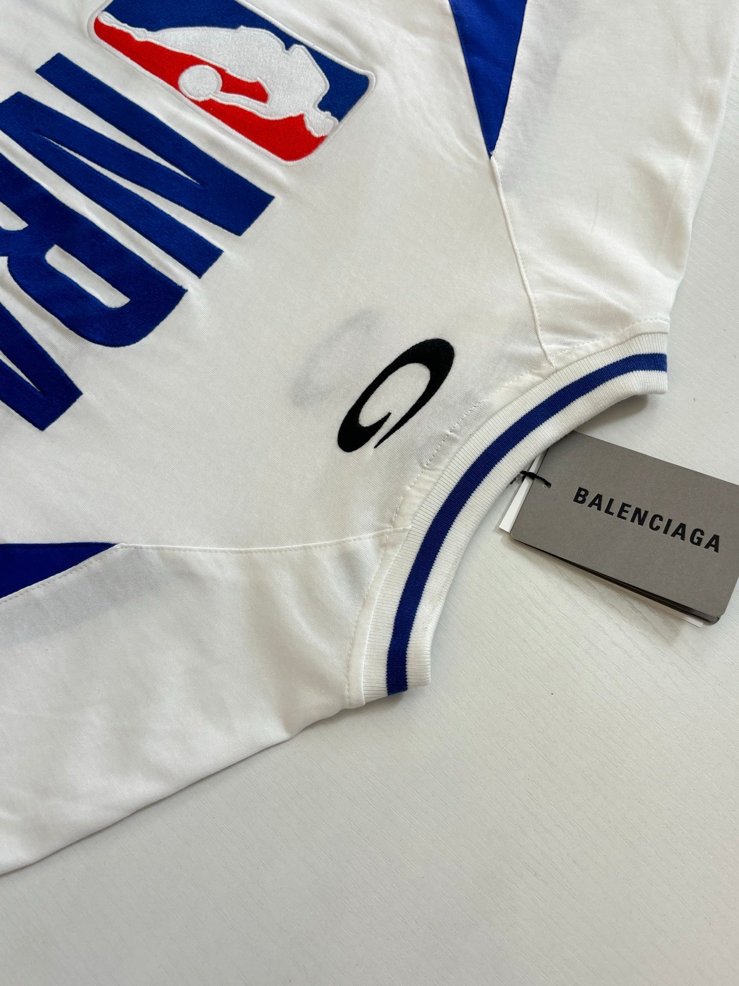 Balenciaga short-sleeve jersey sleeve and chest details with blue stripe and small logo patch