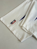 Balenciaga jersey sleeve close-up with small flag logo patch on white fabric