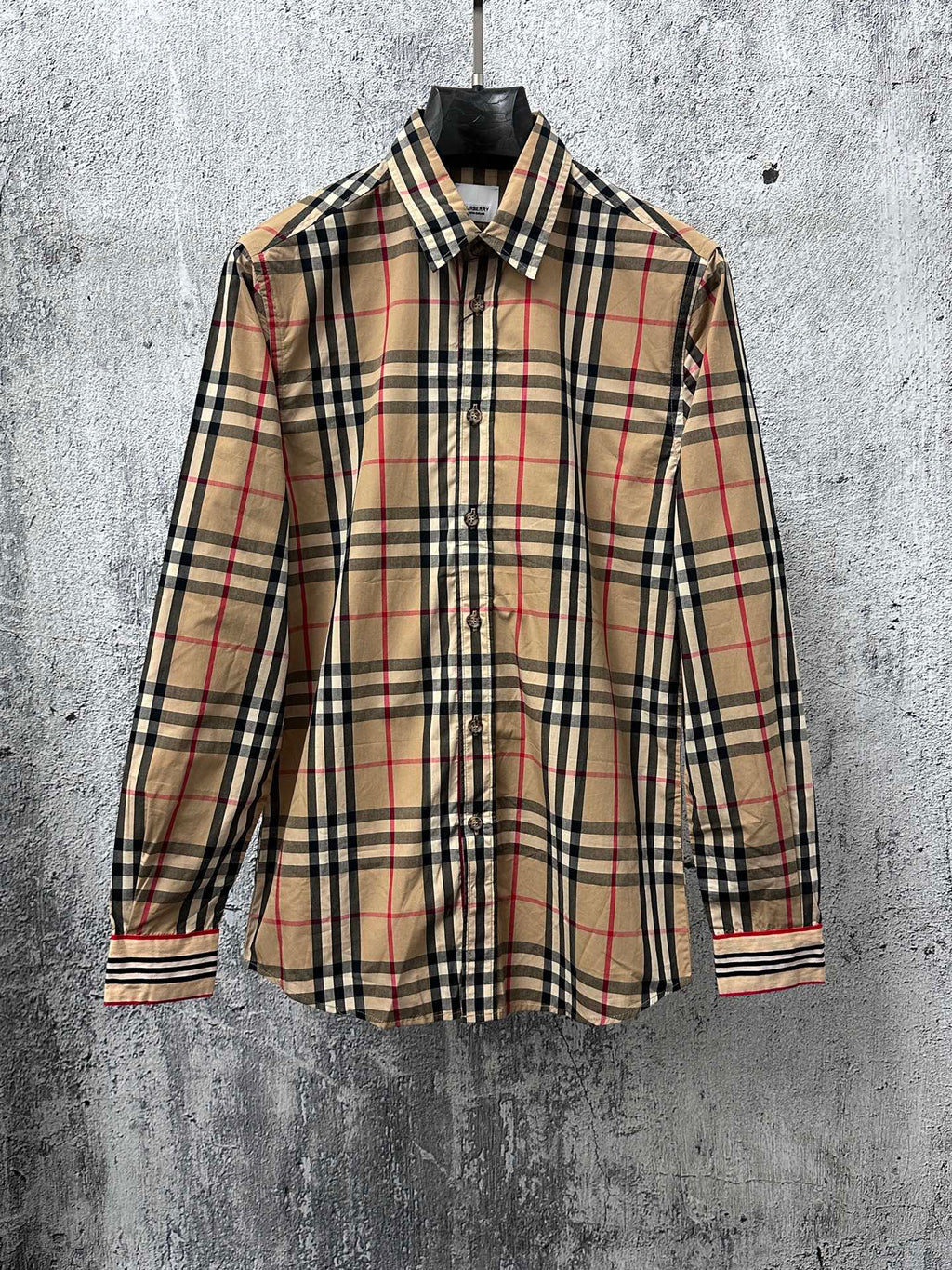 Plaid long-sleeve button-up shirt with black, tan, and red check pattern