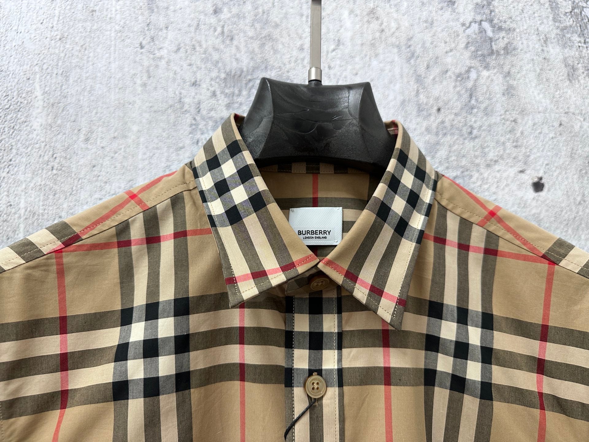 Plaid button-up shirt with pointed collar and button front, visible brand label