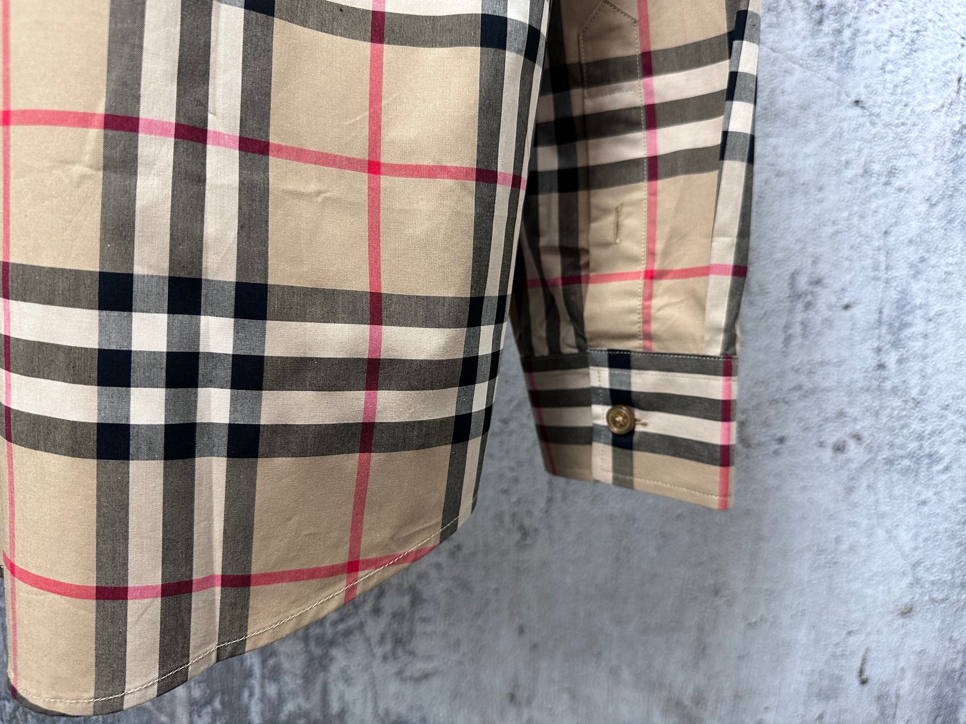 Plaid shirt sleeve and side seam detail with buttoned cuff