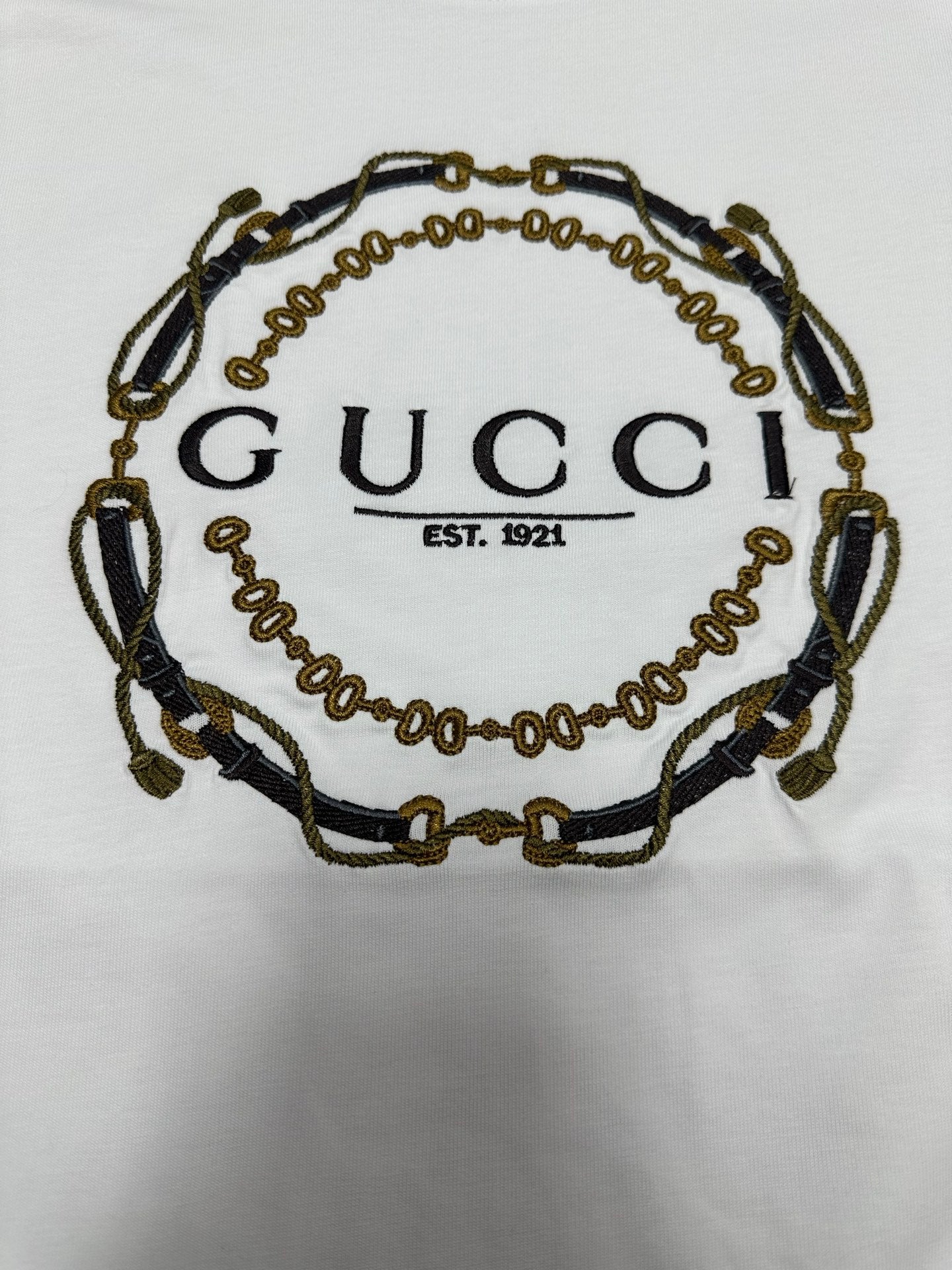 White short-sleeve T-shirt close-up of Gucci chain logo