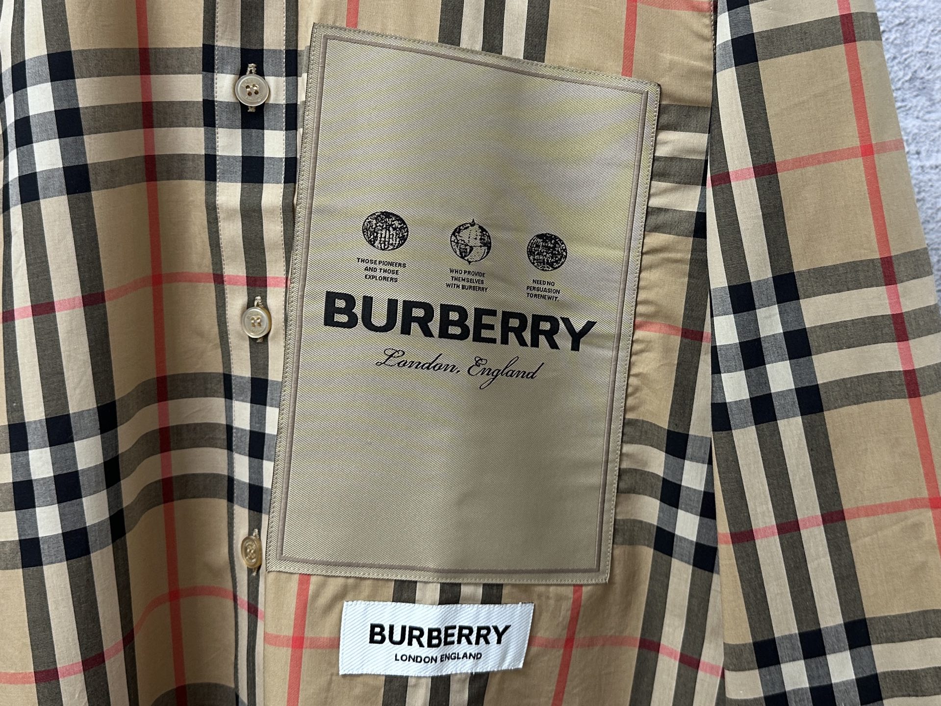 Burberry logo tag on front pocket panel of plaid button-up shirt