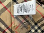 Burberry garment label and care tag on beige plaid fabric with black and red lines