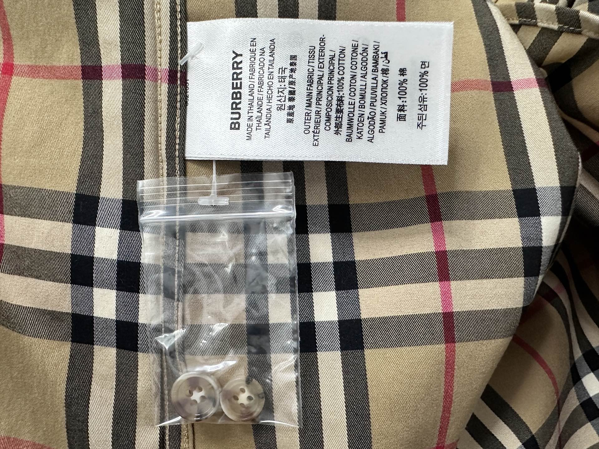 Burberry care label on plaid shirt in beige with navy and red checks