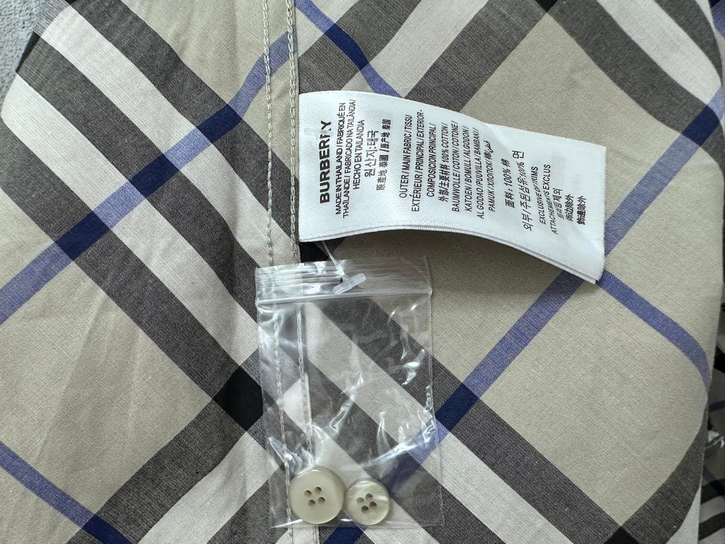 Burberry plaid shirt fabric label and spare buttons in plastic bag