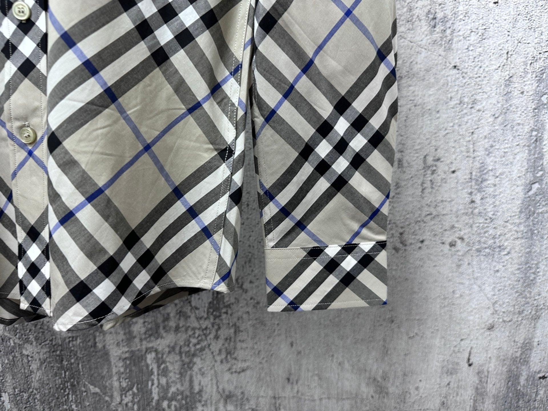 Plaid shirt hem and side seams with buttoned cuffs on both sleeves