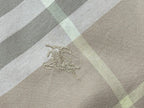 Embroidered crest on light tan and white plaid fabric panel