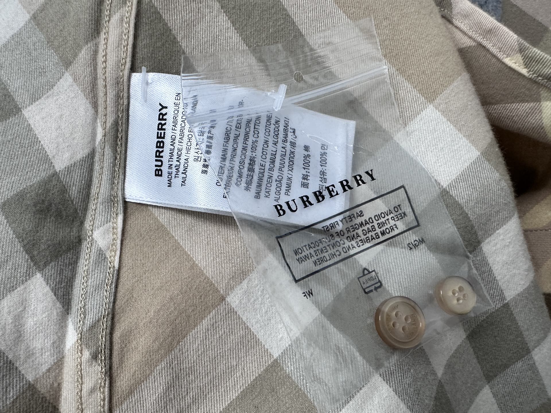 Burberry care label and buttons on plaid shirt, tan and light gray check