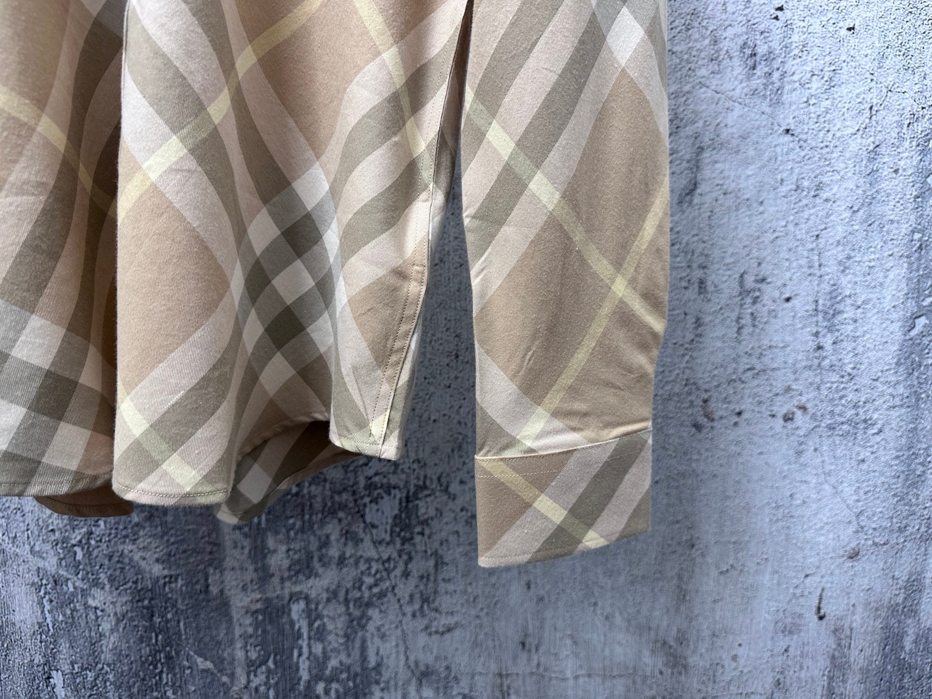 Light tan plaid shirt sleeves and front hem detail with button placket
