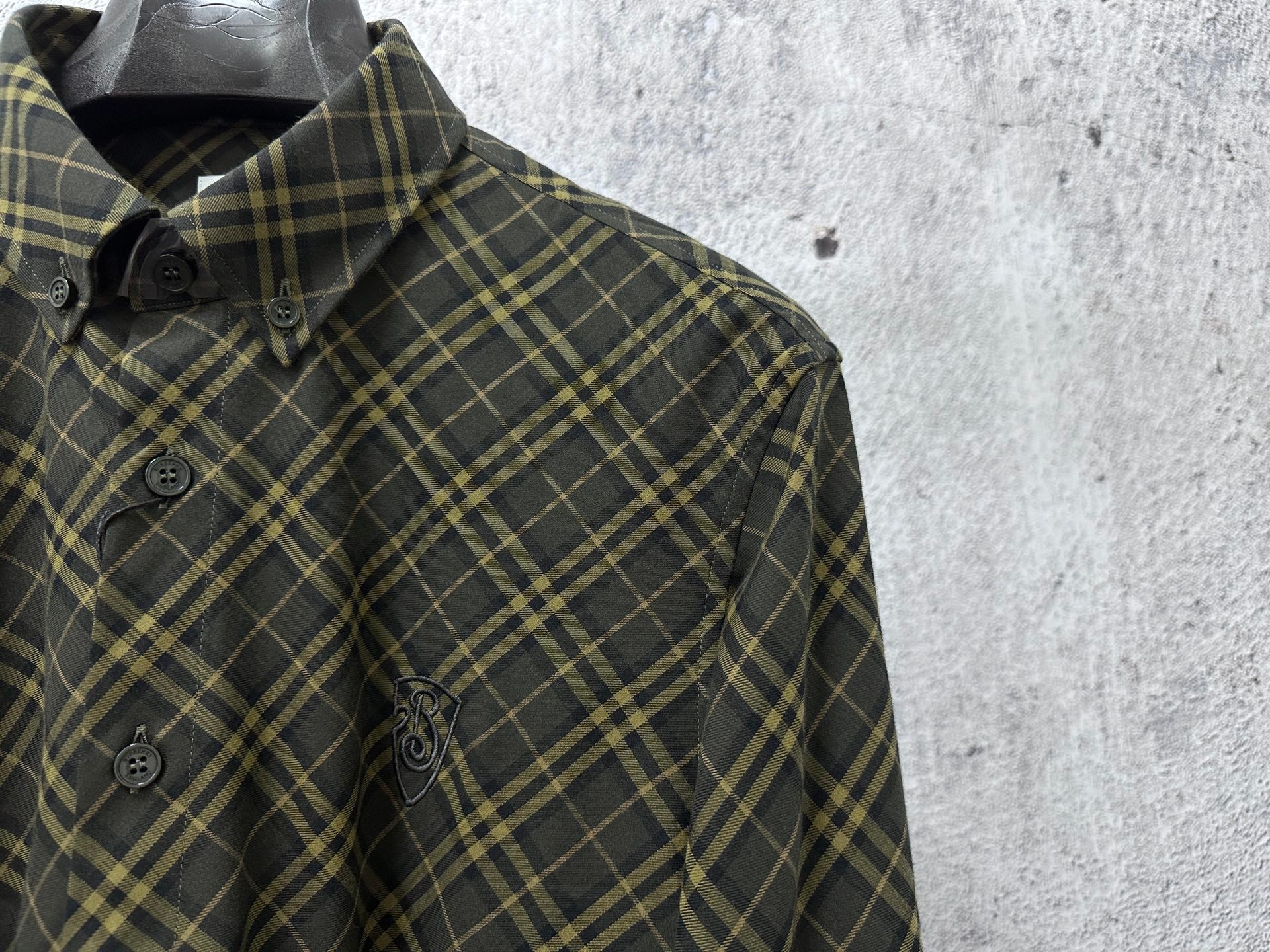 Plaid button-up shirt collar and front buttons in dark green with yellow lines