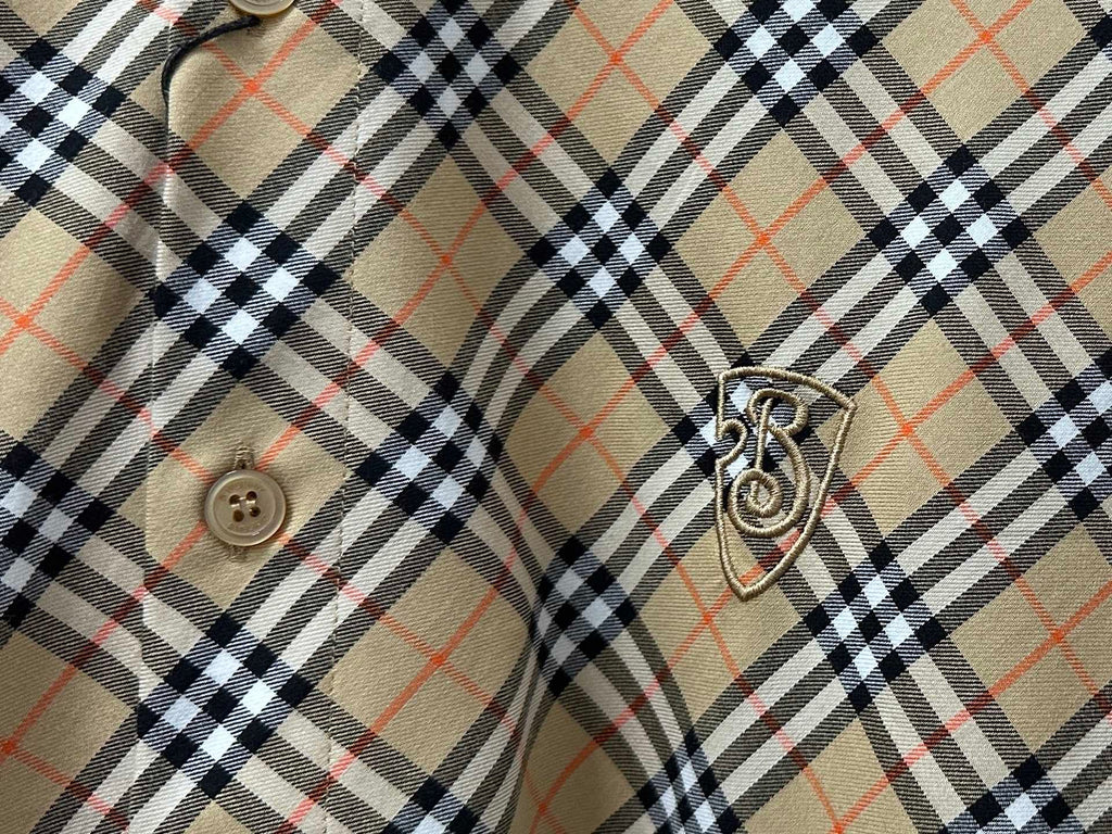 Burberry plaid shirt sleeve detail with crest emblem and button