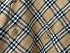 Burberry plaid shirt sleeve detail with crest emblem and button
