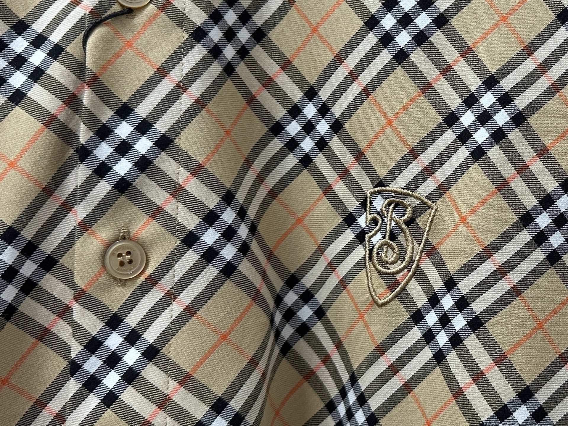 Burberry plaid shirt sleeve detail with crest emblem and button