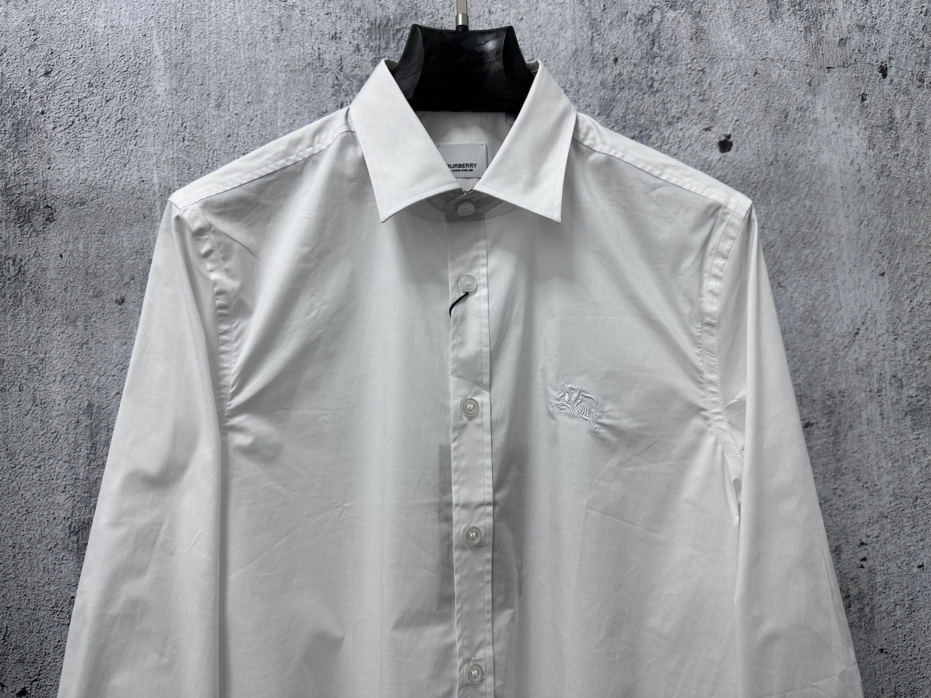 White long-sleeve button-up shirt with logo on left chest