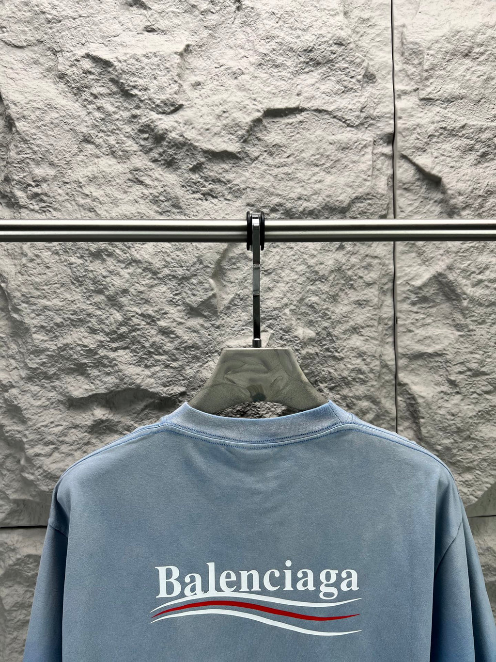 Light blue short-sleeve T-shirt with Balenciaga logo across the back.