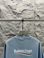 Light blue short-sleeve T-shirt with Balenciaga logo across the back.
