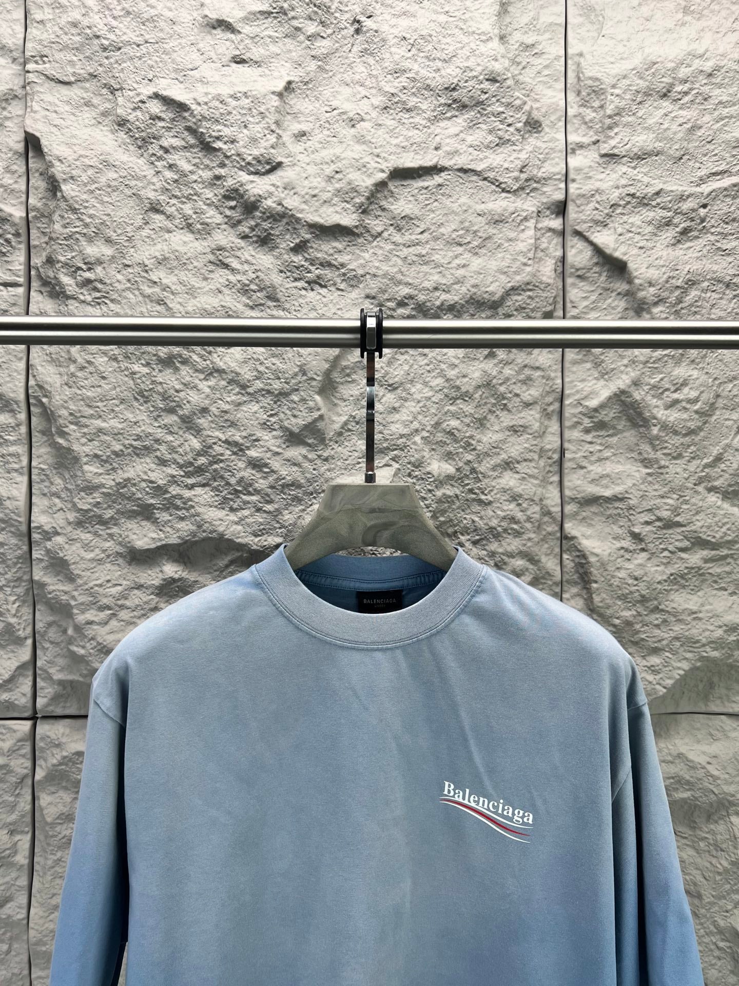 Light blue short-sleeve T-shirt with small Balenciaga logo on the front chest.