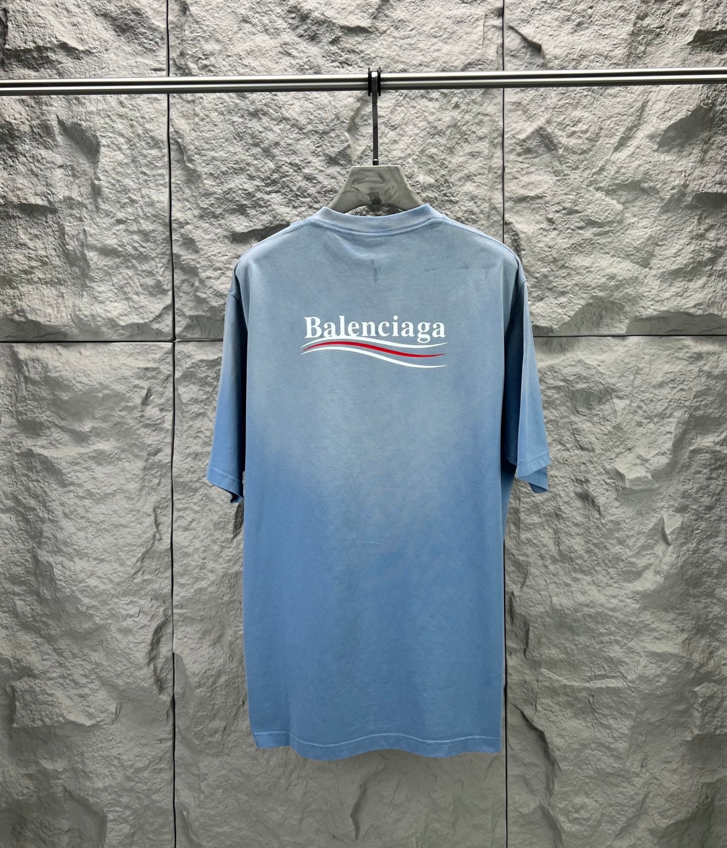 Light blue short-sleeve T-shirt with Balenciaga logo on the back neckline area.
