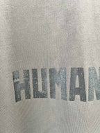 Crew-neck T-shirt fabric with large distressed graphic text print.
