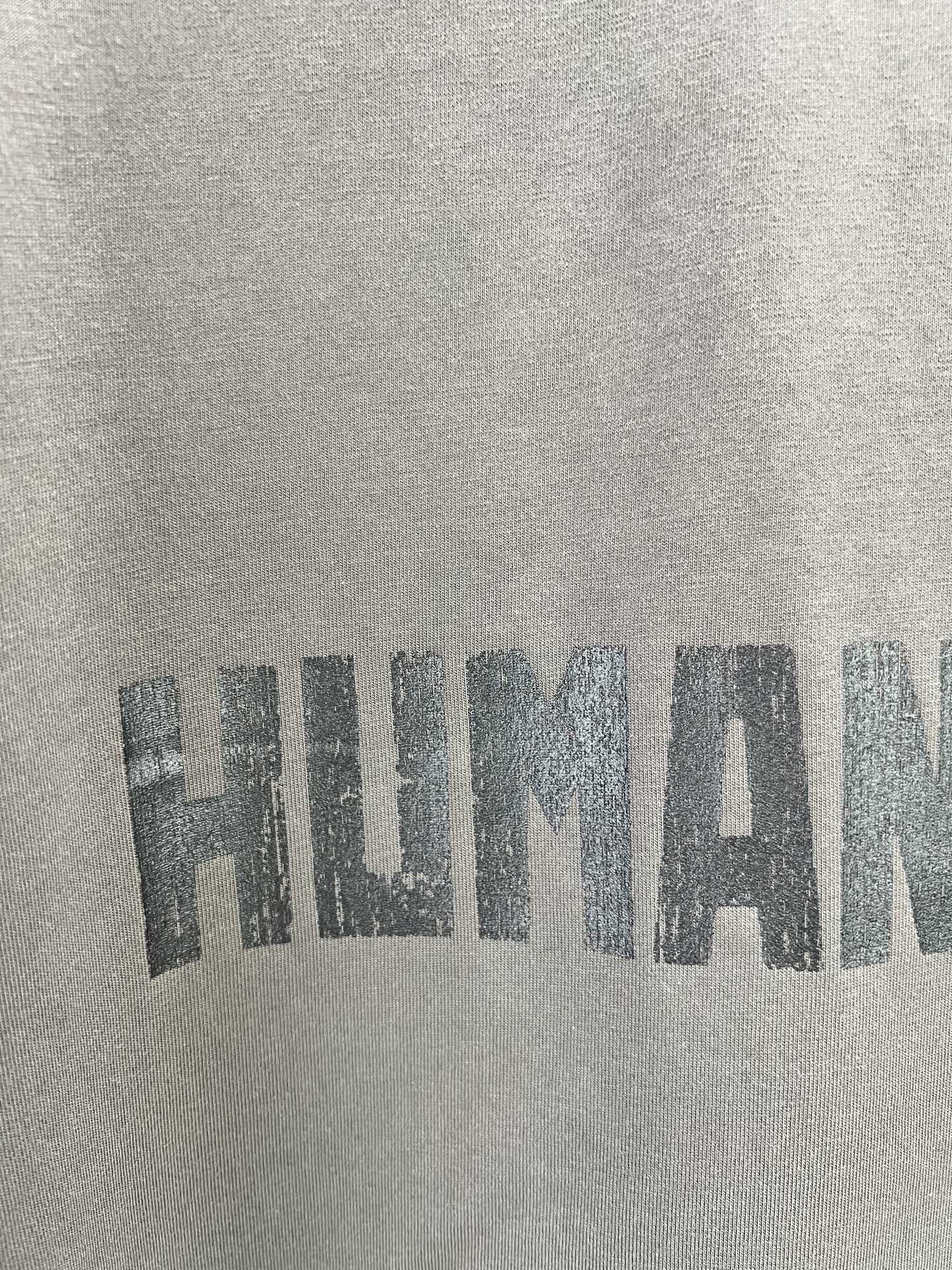 Crew-neck T-shirt fabric with large distressed graphic text print.