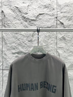 Crew-neck T-shirt, dark gray, front graphic text print close-up.