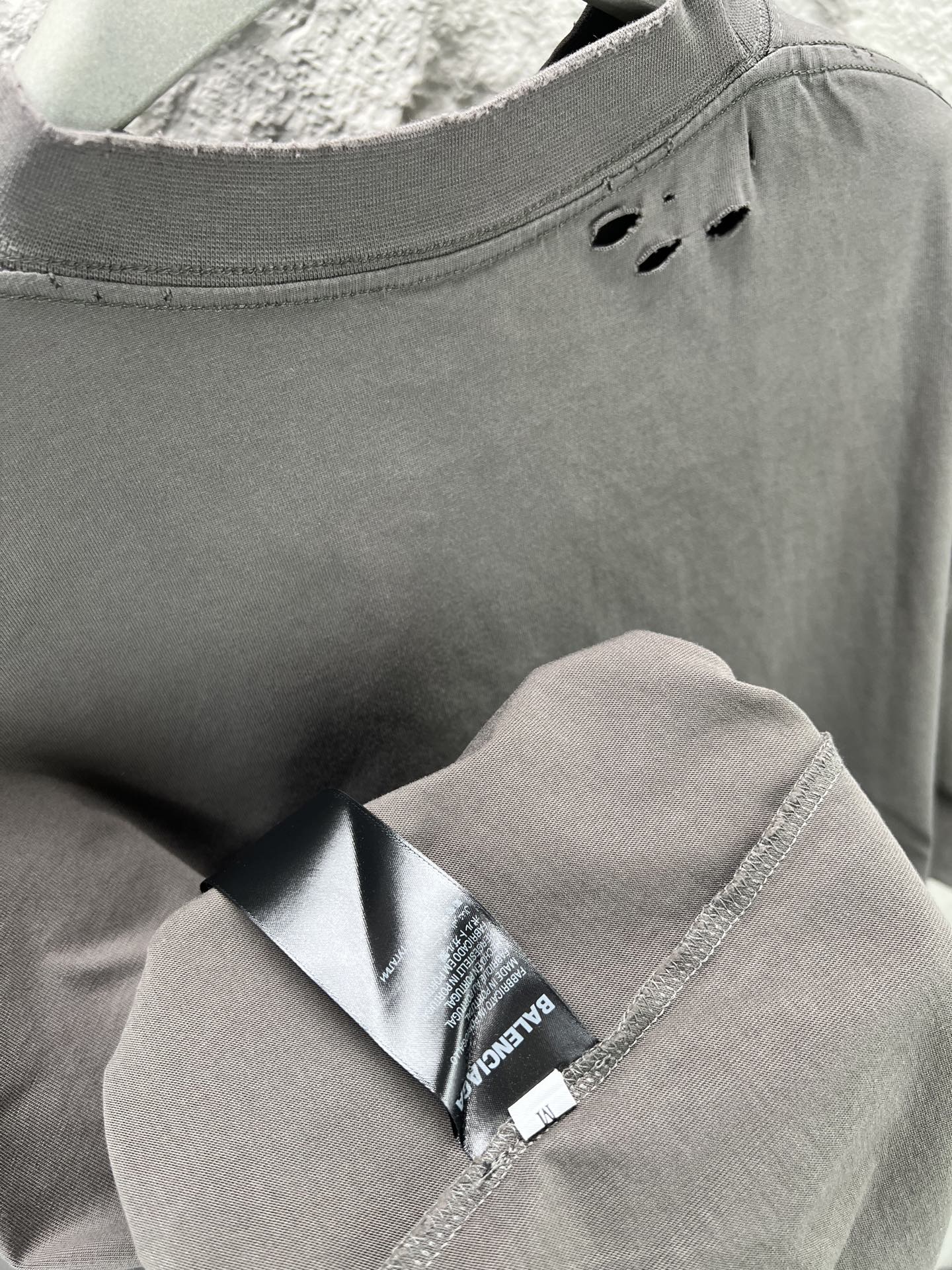 Crew-neck T-shirt collar detail with interior label and stitched neck seam.