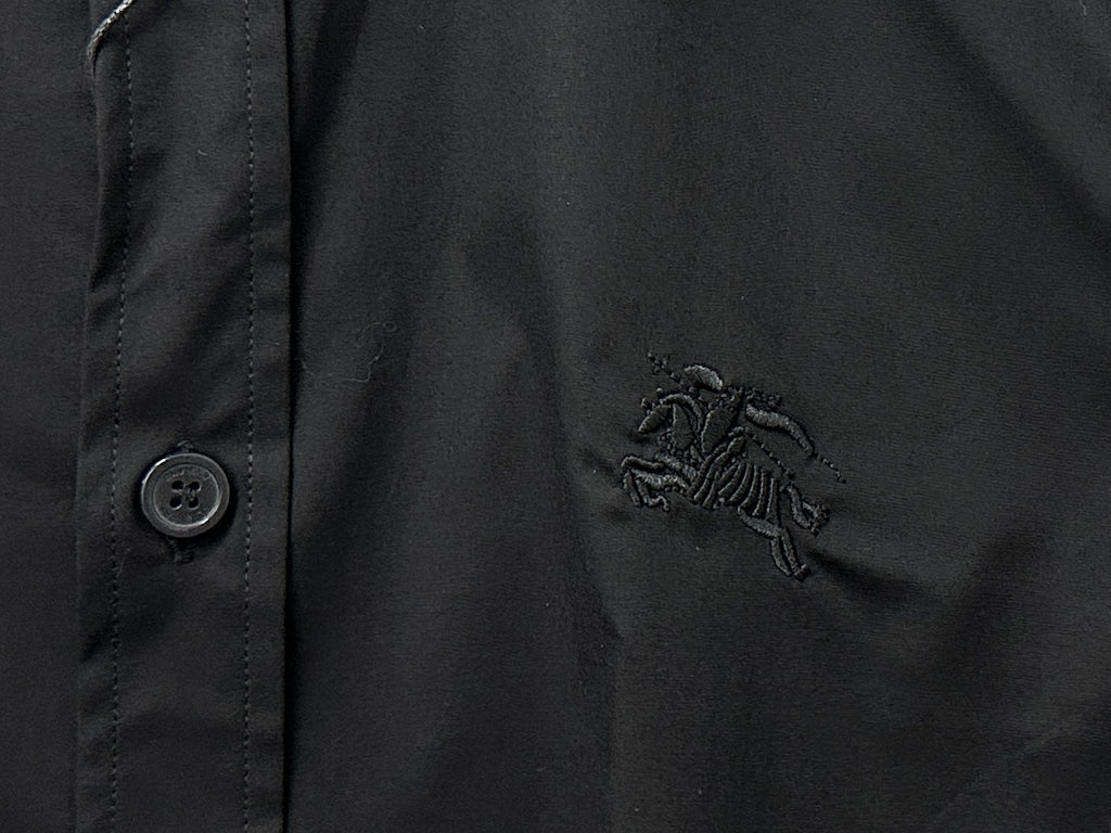 Burberry dark shirt with embroidered logo on chest beside button placket