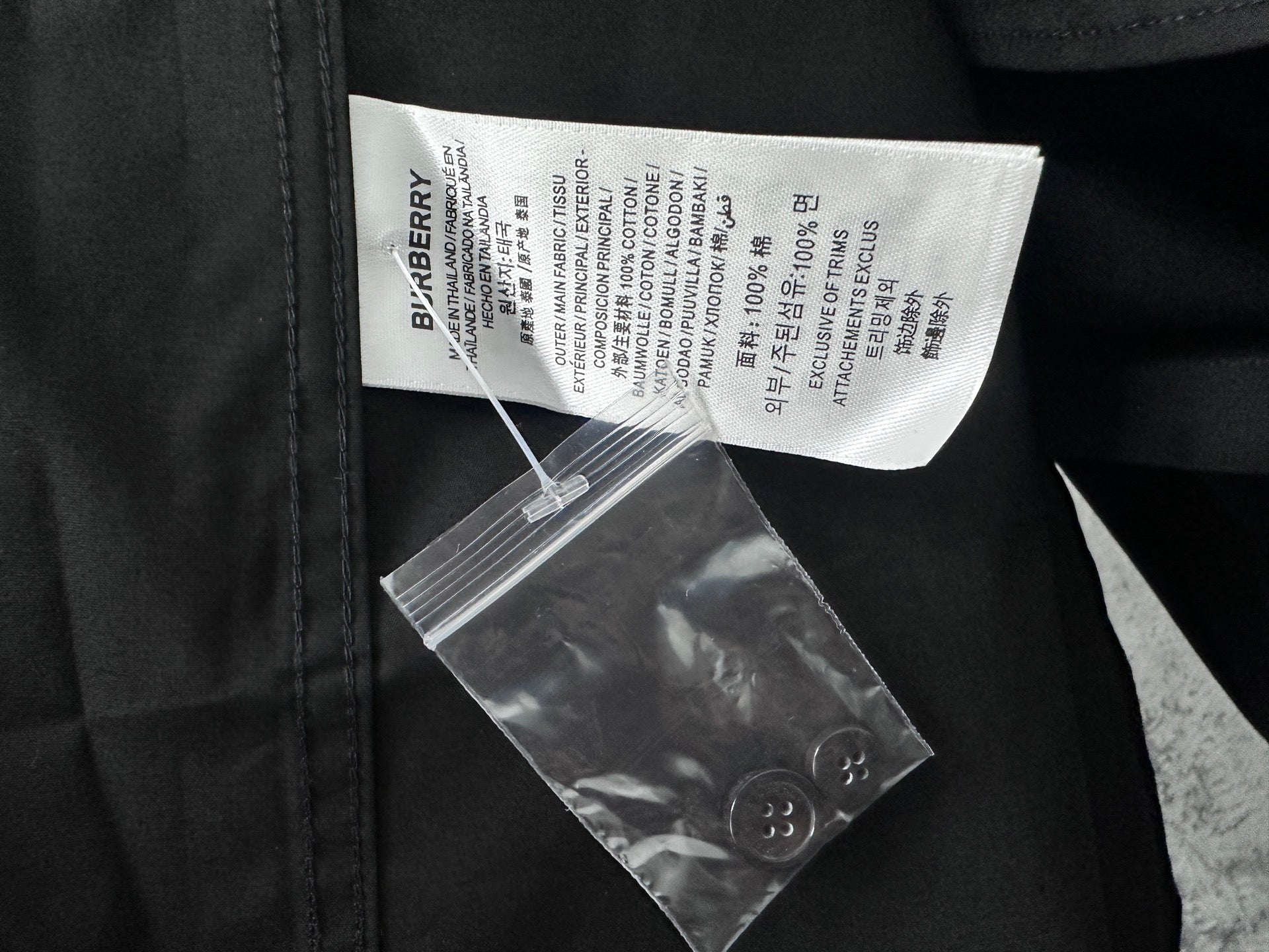 Black Burberry shirt with fabric care label and attached barcode tag