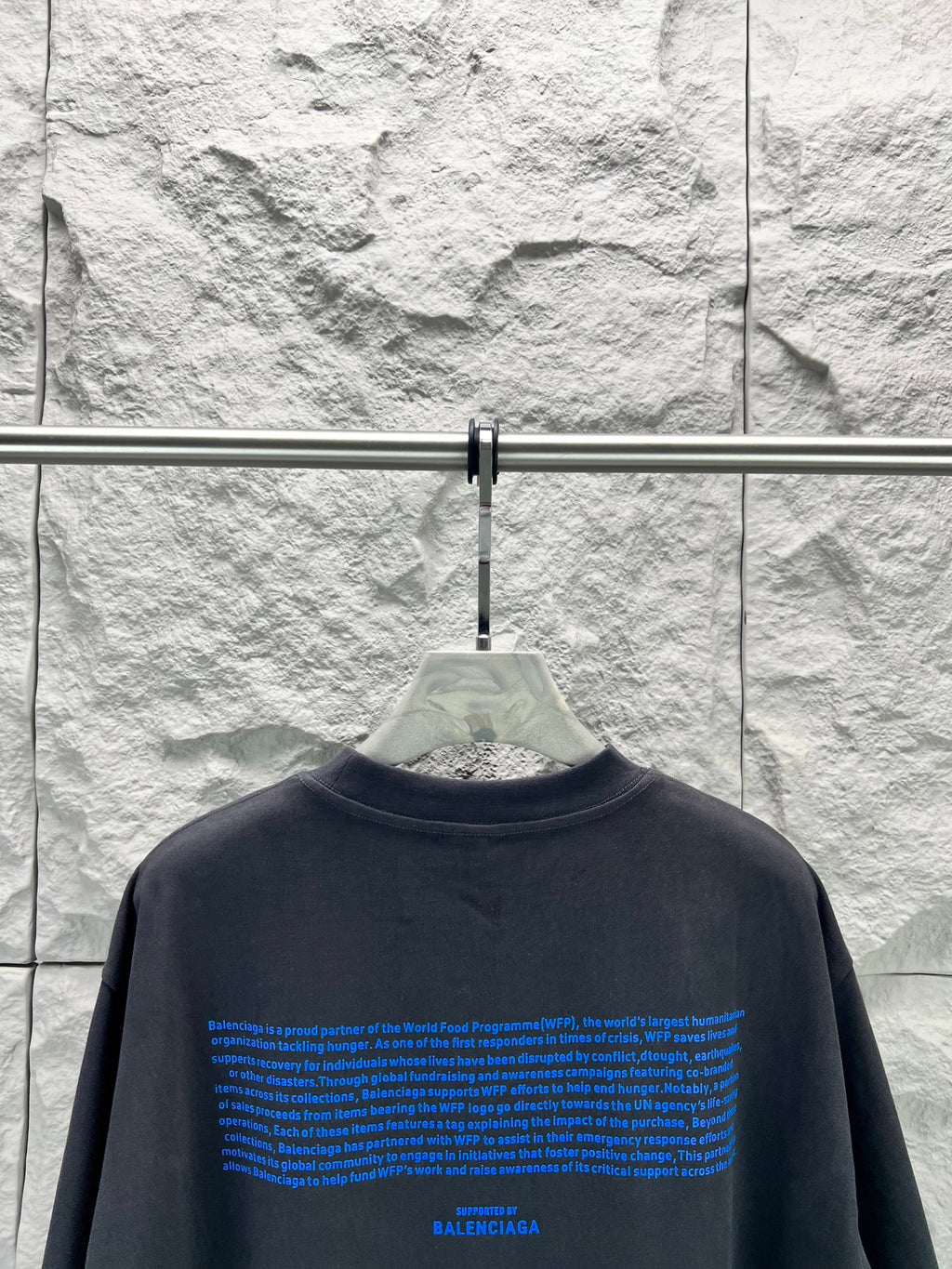 Black short-sleeve T-shirt back with blue long text block and BALENCIAGA at bottom