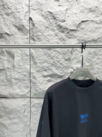 Black short-sleeve T-shirt close-up at chest with small blue WFP Balenciaga logo