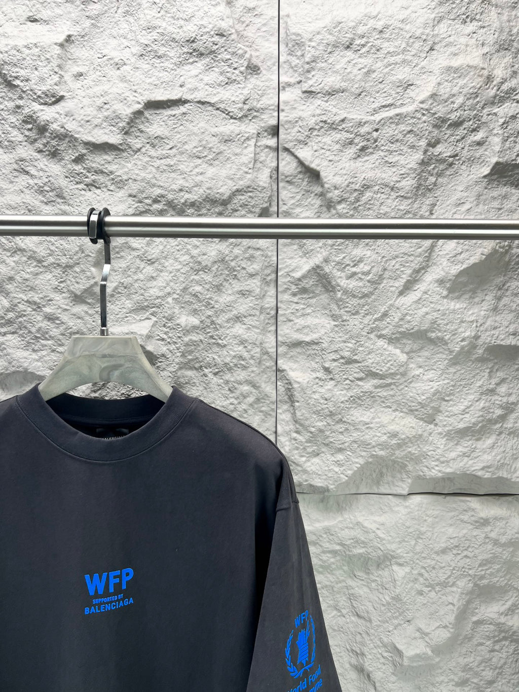 Black short-sleeve T-shirt close-up with blue WFP Balenciaga logo and sleeve print