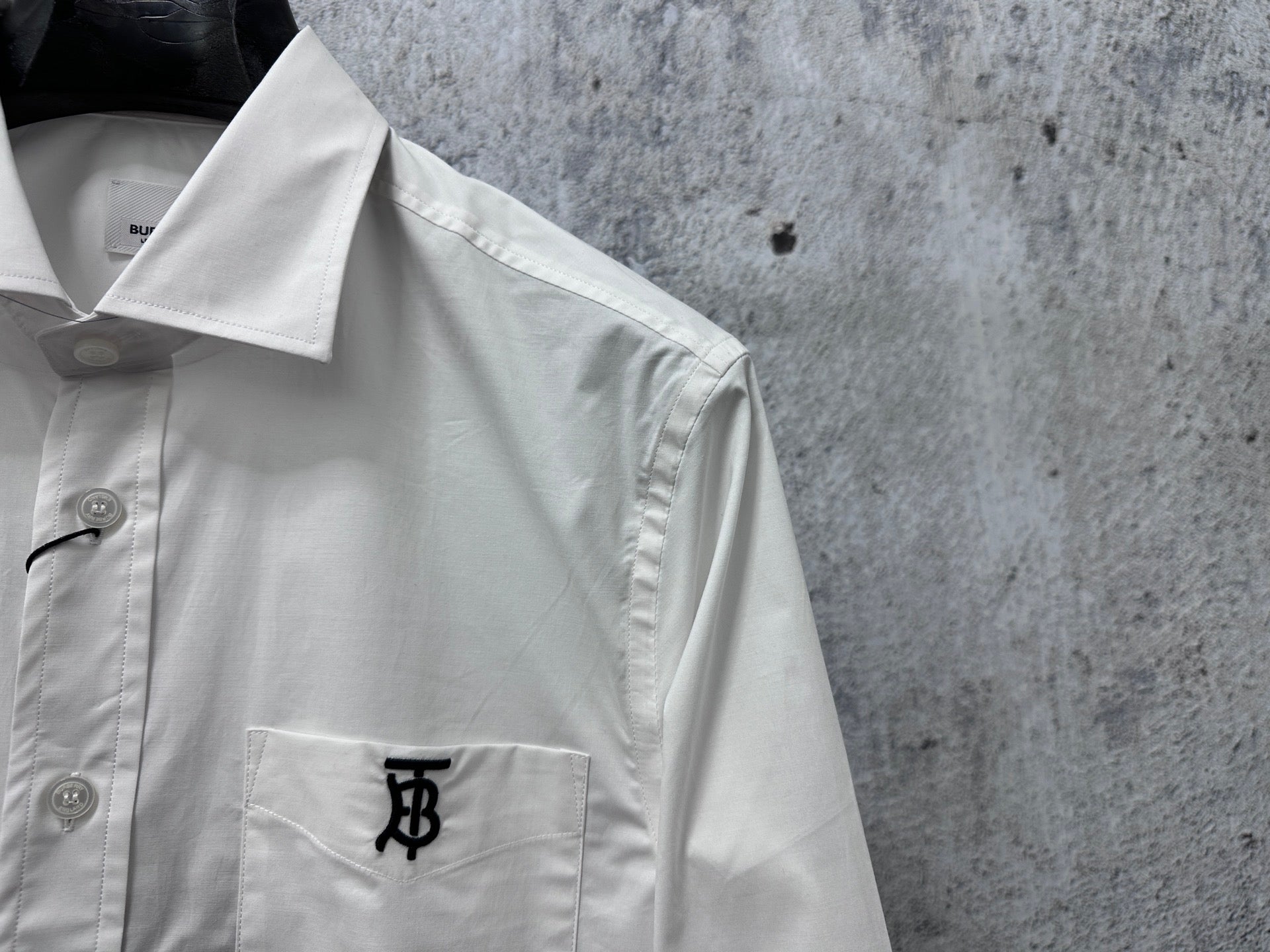 Long-sleeve button-up shirt collar, white, with small neck label and button